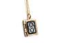 Preview: Tiny gold locket necklace. Dainty rectangular locket with rare black glass hematite