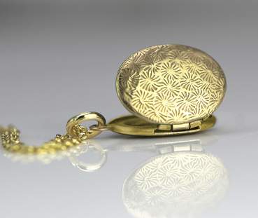 Tiny gold locket necklace. Detail opened.
