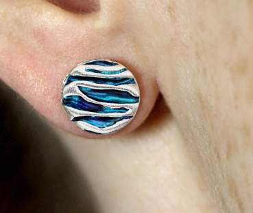 Silver and blue turquoise like ocean waves stud earring worn on one ear.