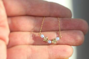 Dainty gold blue opal flower necklace. Tiny flowers and blue cz opal