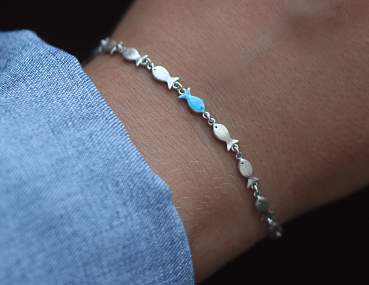 Swimming against the current silver bracelet.School of fish with one blue enameled swimming upstream