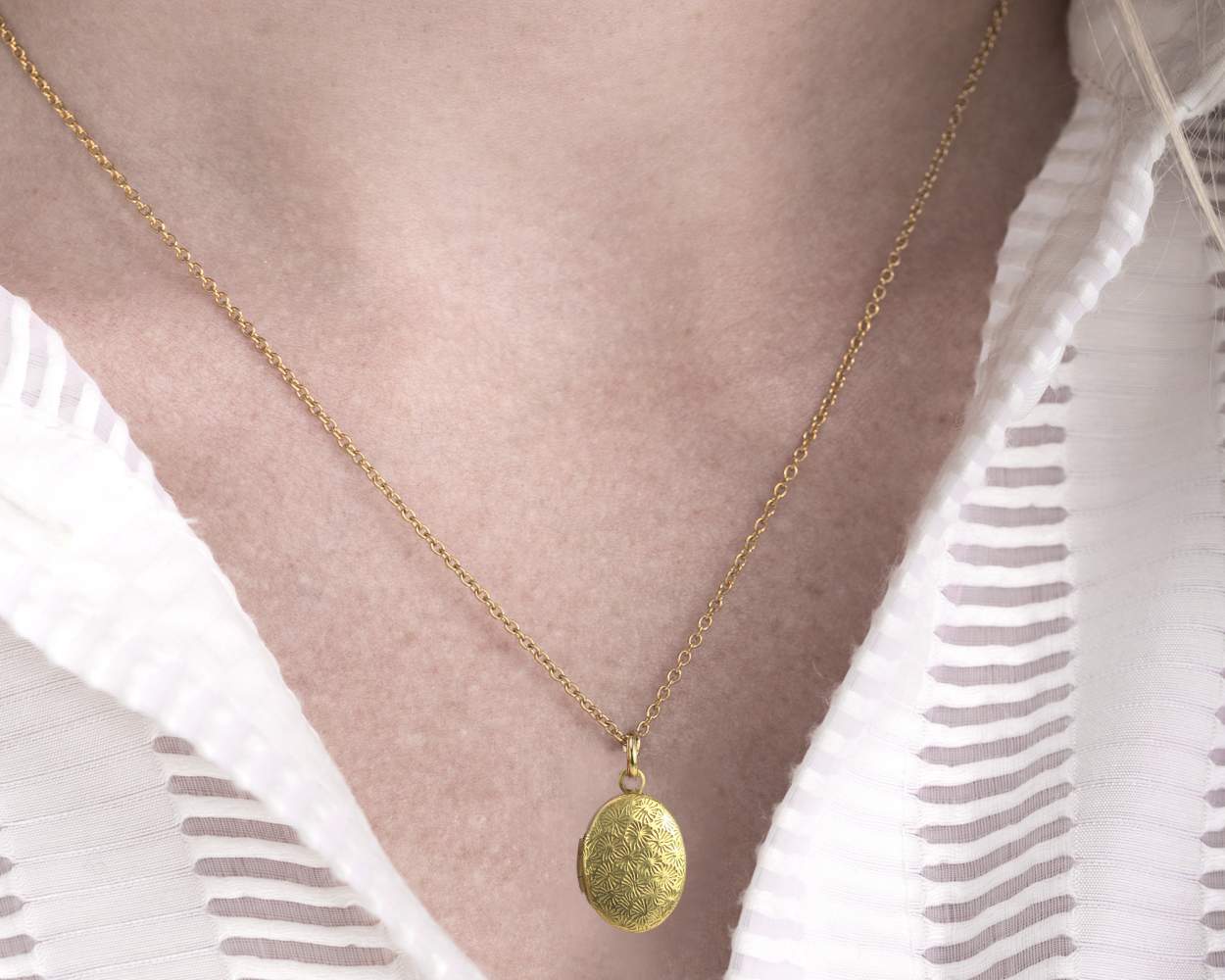Tiny gold locket necklace.