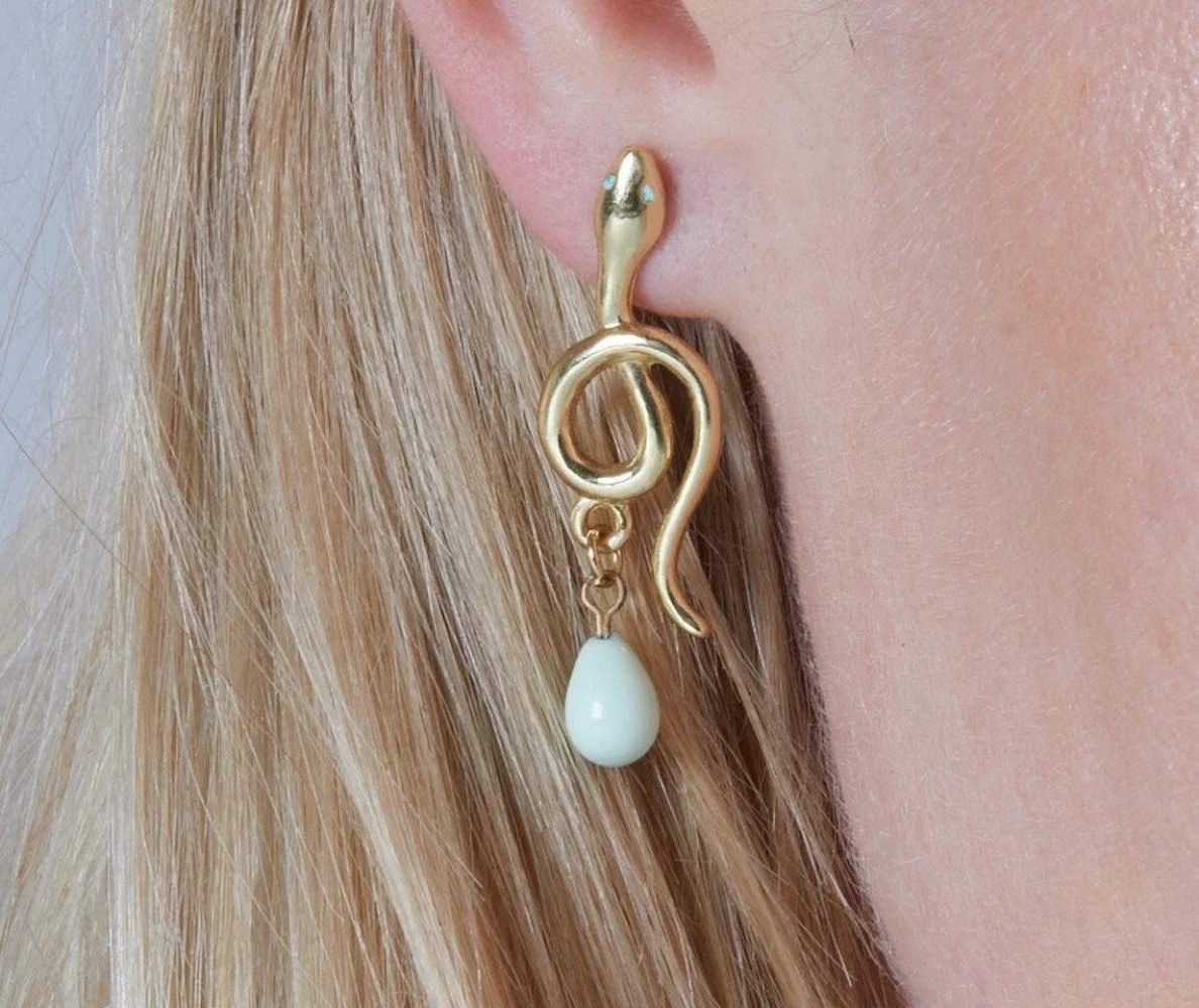 Dangling gold snake stud earrings. Light turquoise eyes and teardrop pearls