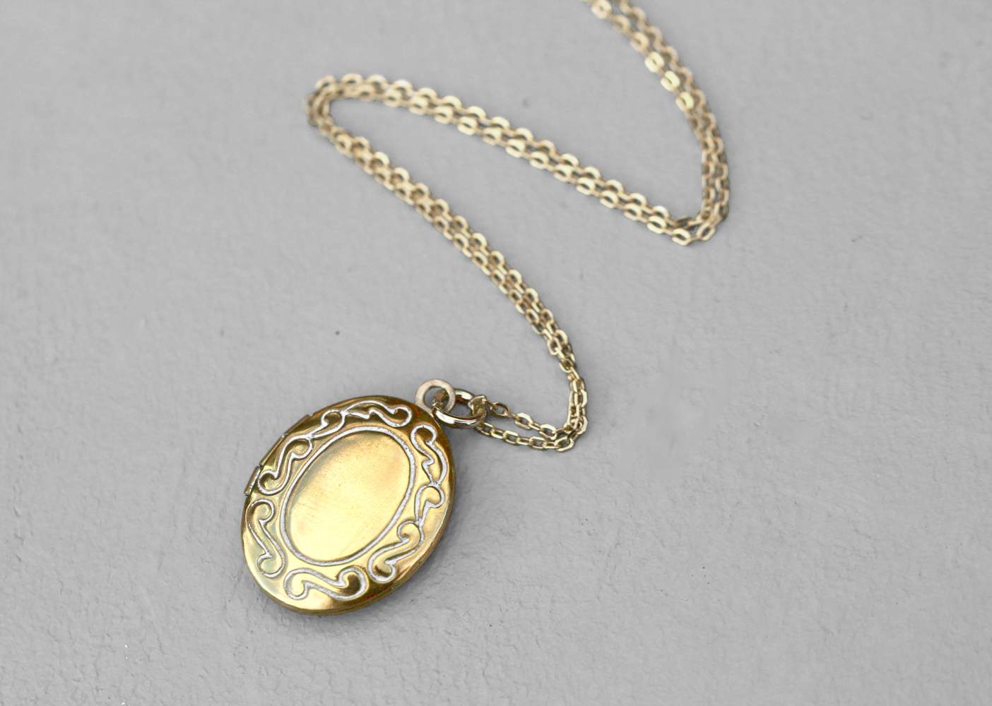 Dainty gold locket necklace with white ornaments. Layering necklace