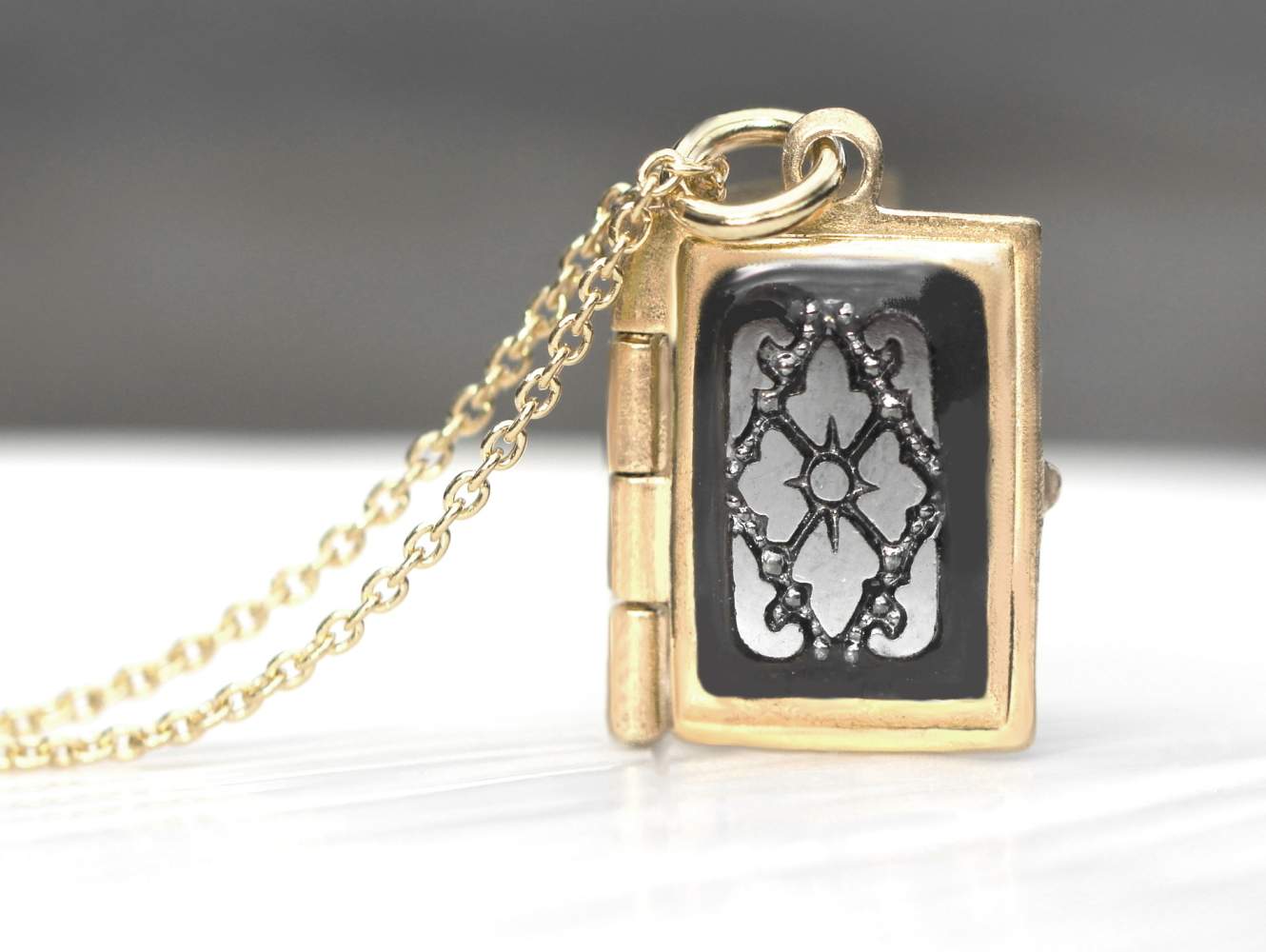 Tiny gold locket necklace. Dainty rectangular locket with rare black glass hematite