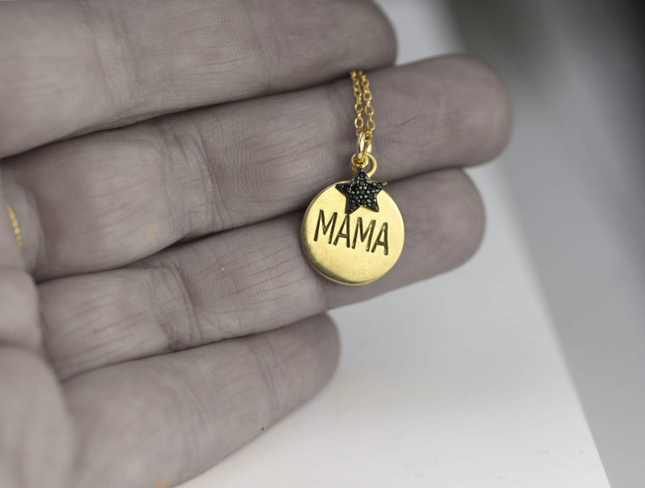 Golden engraved mama pendant with black cubic zirconia star.
