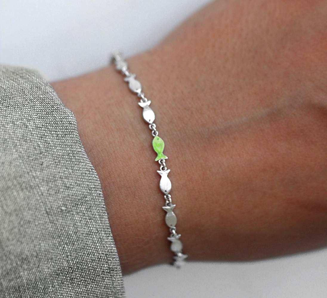 silver fish bracelet with one green fish
